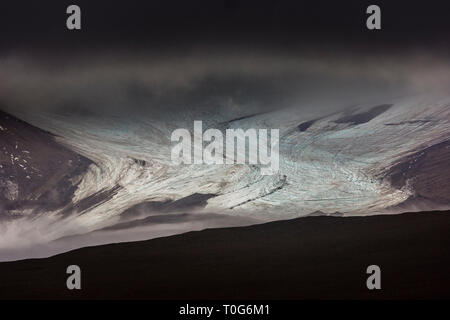 Beautiful moody scenery - Mountain glacier stretching towards Bjorndalen and dark clouds hanging on the mountains Spitsbergen archipelago Stock Photo