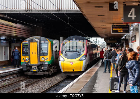 Train approaches Birmingham International Tran Station to pick up passengers on a crowded platform, Birmingham, West Midlands, UK. Stock Photo