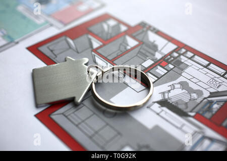 Metal key chain in form miniature house lies Stock Photo