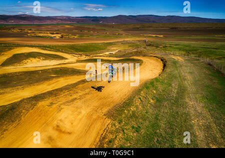 Aerial view of racing motocross bikes in racetrack. Outdoor motor sport from drone view. - Image Stock Photo