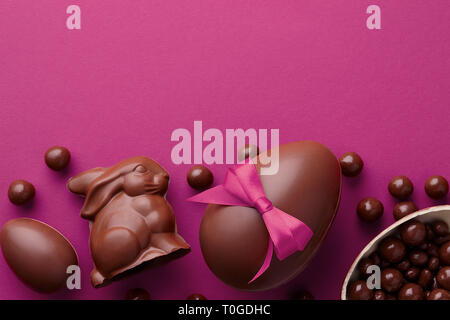 Easter composition with chocolate eggs and bunny on purple background, holiday concept Stock Photo