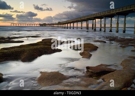 Peaceful, inspiring, tranquil sunset, reflection of clouds on Ocean Beach with pier jutting into Pacific Ocean, San Diego, California. Stock Photo