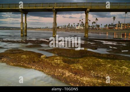 View back toward life guard station on Ocean Beach with pier jutting into Pacific Ocean, at low tide, San Diego, California. Stock Photo