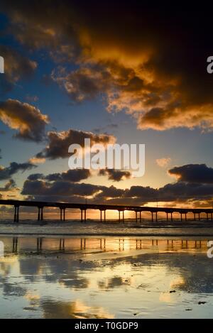 Peaceful, inspiring, tranquil sunset, reflection of clouds on Ocean Beach with pier jutting into Pacific Ocean, San Diego, California. Stock Photo