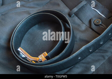 A black leather belt kept on a formal pant trouser Stock Photo