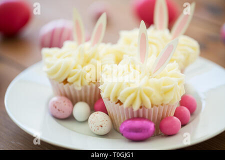 cupcakes with easter eggs and candies on plate Stock Photo