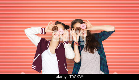 happy teenage girls or friends with donuts on eyes Stock Photo