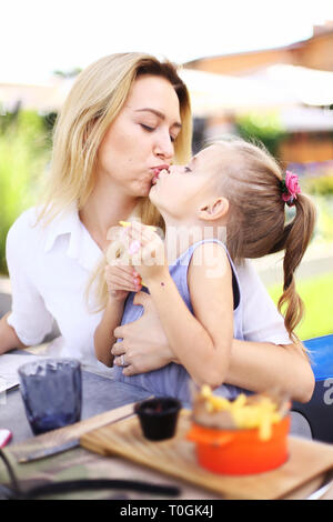  and daughter french kiss Young mother kissing little daughter eating French fries at street cafe  Stock Photo - Alamy