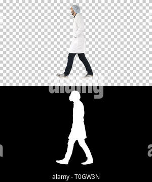 Walking doctor puting medical mask on, Alpha Channel Stock Photo
