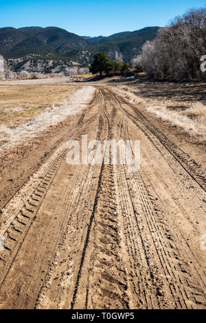 Muddy tire tracks on a ranch dirt road; central Colorado; USA Stock Photo