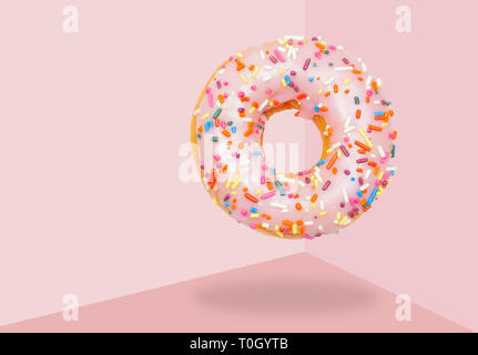 Pink donut with icing on pastel pink background. Stock Photo