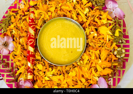 Traditional Haldi turmeric kept on a flower plate for the hindu marriage ceremony Stock Photo