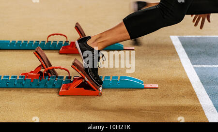 Sport. Sprinter leaving starting blocks on the running track. Stock Photo