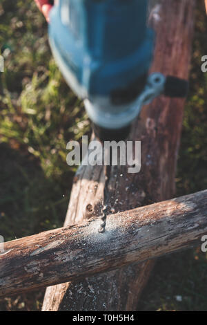 Drilling hole in timber while working in garden Stock Photo