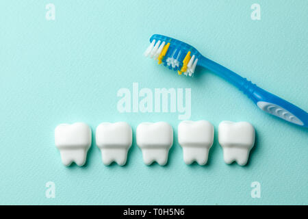 Healthy white teeth on mint green background with toothbrush. Stock Photo