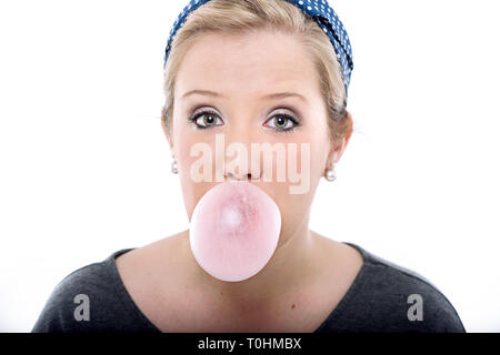 Pretty young blond woman with big, bright eyes, wearing a cute retro outfit, blowing pink bubble gum.