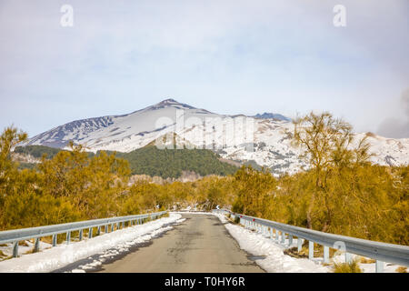 Road to volcano and snow covered Etna Mount, Sicily in Italy Stock Photo