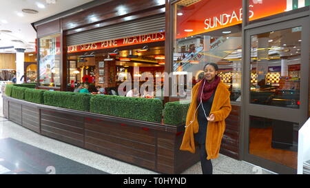 Young lady out shopping in Harrow, London, United Kingdom Stock Photo