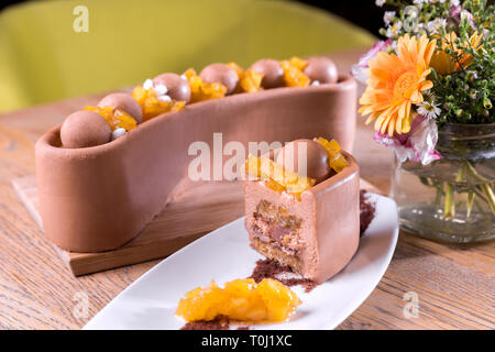 Homemade milk chocolate and chestnuts cake - milk chocolate mousse, pineapple marmalade, crispy base with hazelnuts and fuiglettine, chestnut cake. Stock Photo