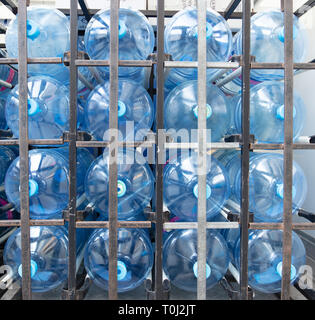 Group of large plastic water bottles neatly stacked in a frame inside a van for delivery to offices and other customers in central London, UK. Stock Photo