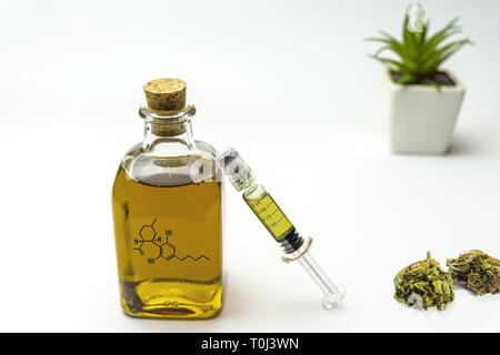 Cbd oil in glass bottle with molecule drawing, syringe, and hemp flower Stock Photo