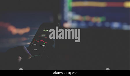 Close up of businessman in dark using mobile smart phone. Focus on mobile device Stock Photo