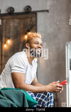Nice good looking man sitting with his phone Stock Photo