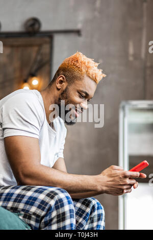 Delighted nice man looking at his smartphone screen Stock Photo