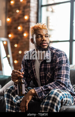 Pleasant young man being dressed in pyjamas Stock Photo