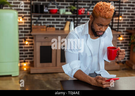 Nice young man holding his smartphone in the hand Stock Photo