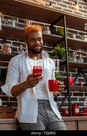 Pleasant good looking man using his smartphone Stock Photo