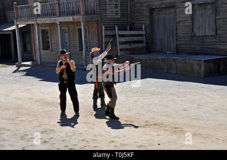 Cowboy actors re-enact a gunfight scene for tourists on a former Western film set in Tabernas, Almeria, Spain. Stock Photo