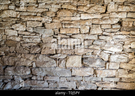 Close up of old flat brown and gray stone wall texture. Layered rocks on a house or building. Architectural stone wall exterior typical in Bulgaria Stock Photo