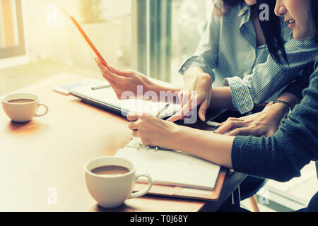 Two Asian business woman working together with digital tablet in office. Business team concept Stock Photo