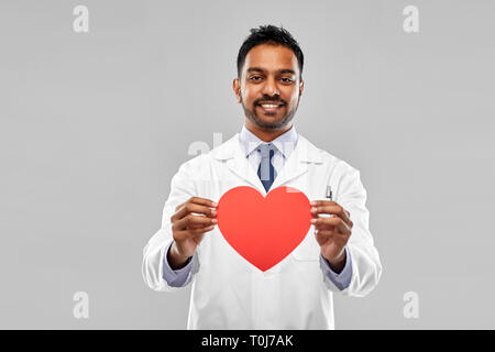 smiling indian male doctor with red heart shape Stock Photo