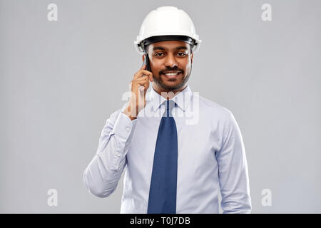 indian architect in helmet calling on smartphone Stock Photo