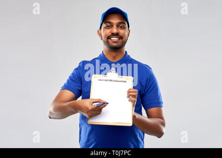 happy indian delivery man with clipboard in blue Stock Photo