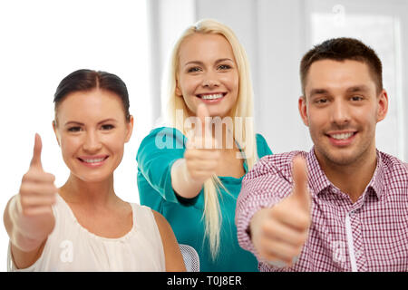 happy creative team showing thumbs up at office Stock Photo - Alamy