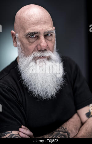 Handsome bald man with beard and tattoo wearing glasses and sweater ...