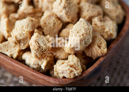 Raw soya chunks, soy meat for vegans in wooden bowl Stock Photo