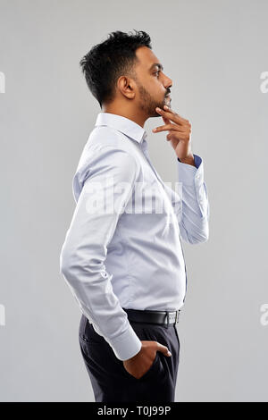 indian businessman side view over grey background Stock Photo
