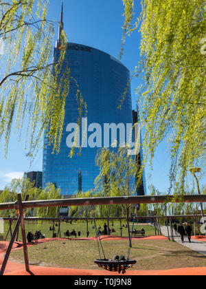 Library of Trees, relaxation area with benches and swings. Unicredit tower, People walking. Weeping willow. Park in Milan, Italy Stock Photo