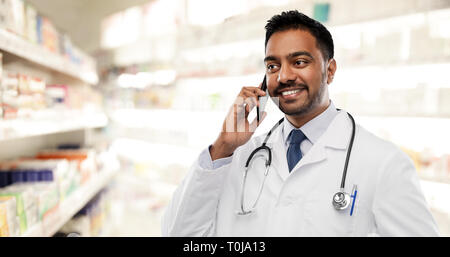 smiling indian male doctor calling on smartphone Stock Photo