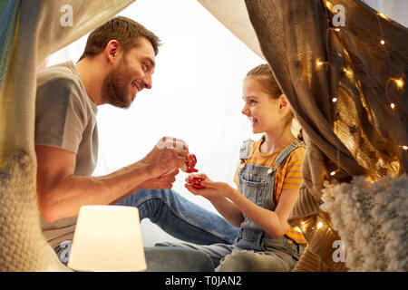 family playing tea party in kids tent at home Stock Photo