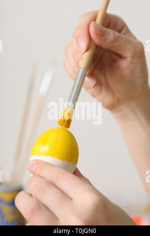 Close up of woman hands coloring easter eggs Stock Photo