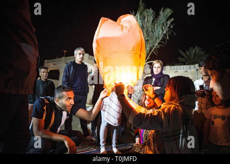 Qeshm Island, Iran. 19th Mar, 2019. People release a wishing lantern in the celebrations of the fire festival in Qeshm Island, southern Iran, on March 19, 2019. The fire festival, a 4,000-year Persian tradition, is celebrated by Iranians on the eve of the last Wednesday before Nowruz (the Iranian new year). Credit: Ahmad Halabisaz/Xinhua/Alamy Live News Stock Photo