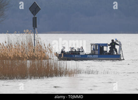 Wolzig, Germany. 20th Mar, 2019. Policemen in a boat drive across Lake Wolziger See in the district of Dahme-Spreewald. On the same day the search for the missing Rebecca from Berlin was continued. Police divers from Berlin are also on duty. Credit: Patrick Pleul/dpa-Zentralbild/dpa/Alamy Live News Stock Photo