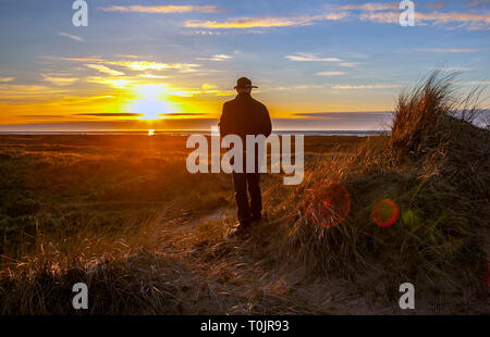 Southport, Merseyside. 20th March 2019. UK Weather. Colourful sunset over the Irish Sea and Ainsdale Sand Dunes National Nature Reserve (NNR), which is a coastal site comprising rare dunes, beach and woodland habitats. Credit: MediaWorldImages/Alamy Live News Stock Photo