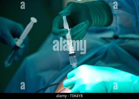 Close up picture of doctor 's hand while inject the anesthetic agent under the patient 's skin. Local anesthesia was use before perform surgery Stock Photo