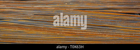 Steel bars texture background. Rusty metal reinforcement rods pile at a construction site, banner Stock Photo